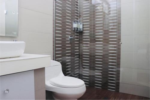 a white bathroom with a toilet and a shower at Alojamiento espectacular, cerca al Malecón del Río, Puerta de Oro y CC Buenavista - Duchas con agua caliente in Barranquilla