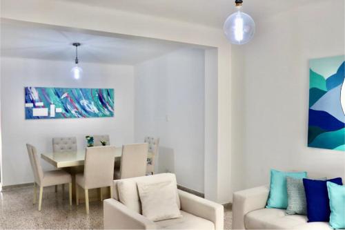 a living room with a table and chairs and a dining room at Alojamiento espectacular, cerca al Malecón del Río, Puerta de Oro y CC Buenavista - Duchas con agua caliente in Barranquilla