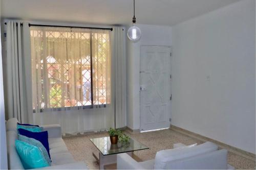 sala de estar con sofá blanco y mesa de cristal en Alojamiento espectacular, cerca al Malecón del Río, Puerta de Oro y CC Buenavista - Duchas con agua caliente, en Barranquilla