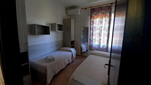 Habitación pequeña con 2 camas y ventana en Casa Maria Orosei-Cala Liberotto, en Cala Liberotto