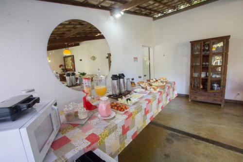 a room with a table with food and a mirror at Vila Flores Pousada in Serra do Cipo