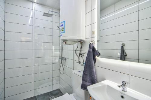 a white bathroom with a sink and a toilet at House Stavrevi in Varna City