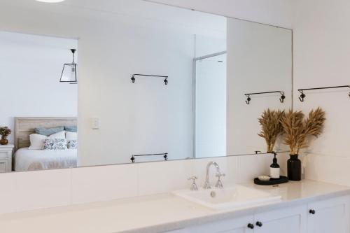 a bathroom with a sink and a large mirror at Drift House in Quindalup