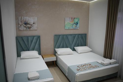a room with two beds and two pictures on the wall at Apartments Costa Azzurra in Velipojë