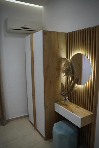 a bathroom with a mirror on a wooden wall at Apartments Costa Azzurra in Velipojë