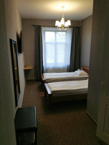 a hotel room with two beds and a window at Hotel Kārklu Muiža in Jelgava