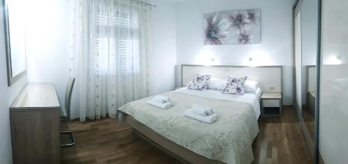 ein weißes Schlafzimmer mit einem Bett, auf dem zwei Handtücher liegen in der Unterkunft ANTE Accommodation in Seline