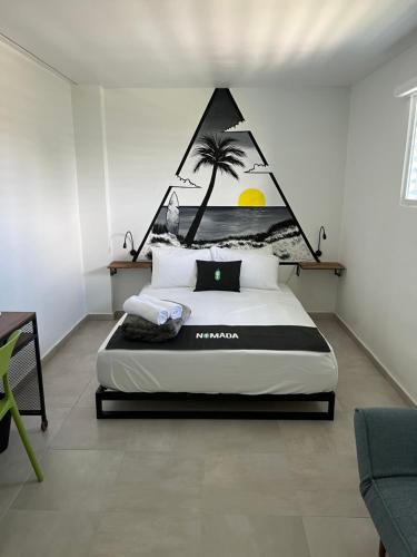 a bedroom with a bed with a palm tree mural on the wall at Nomada Beach Hostel- Isla Verde in San Juan