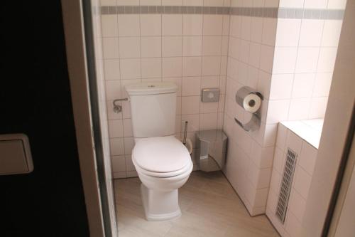 a bathroom with a white toilet in a stall at Hotel-Maison Am Olivaer Platz in Berlin