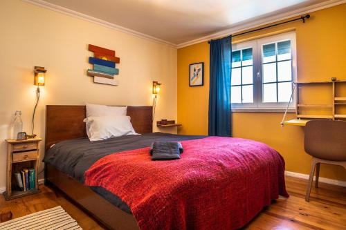 um quarto com uma cama com um cobertor vermelho e uma janela em Ahoy Surf House em Ferrel