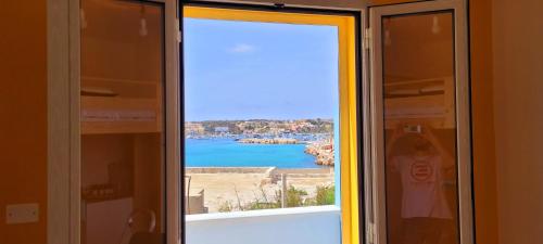 - une fenêtre avec vue sur une étendue d'eau dans l'établissement Il maestro di nodi - Casa vista mare, à Lampedusa