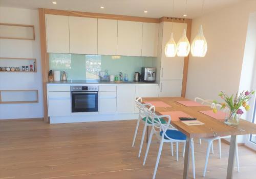 塞基興的住宿－Haus am Weinberg，厨房配有木桌和白色橱柜。