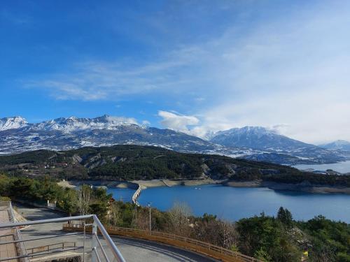 a view of a lake with snow capped mountains at leparadisachorges in Chorges