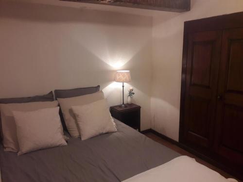 a bedroom with a bed with two pillows and a lamp at Apartment in the heart of Cotignac in Cotignac