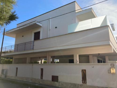 ein weißes Haus mit vielen Fenstern in der Unterkunft Appartamento a pochi passi dal mare in Porto Cesareo