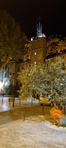 a building with a clock tower at night at Apartment in the heart of Cotignac in Cotignac