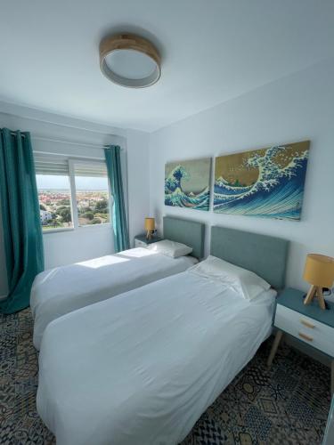 2 łóżka w pokoju hotelowym z niebieskimi ścianami w obiekcie Apartamento edificio Goya w mieście Mar de Cristal