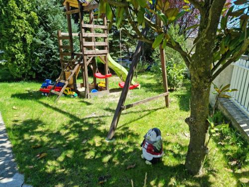 a toy dog sitting in the grass next to a playground at Balaton Holiday in Fonyód