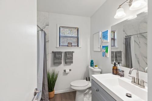 Baño blanco con lavabo y aseo en The Florida Keys Treehouse in Marathon, FL, en Marathon