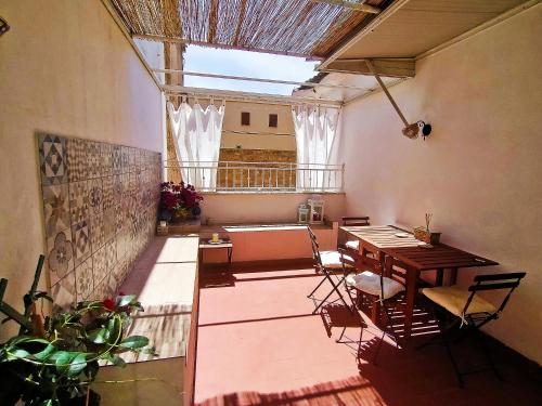a room with a table and chairs and a balcony at Le terrazze segrete in Palermo
