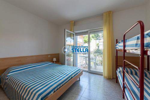 a bedroom with a bunk bed and a balcony at Residence Adriatica in Lido di Jesolo