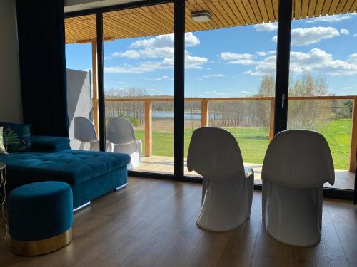 a living room with a blue couch and white chairs at Glemuria in Kętrzyn
