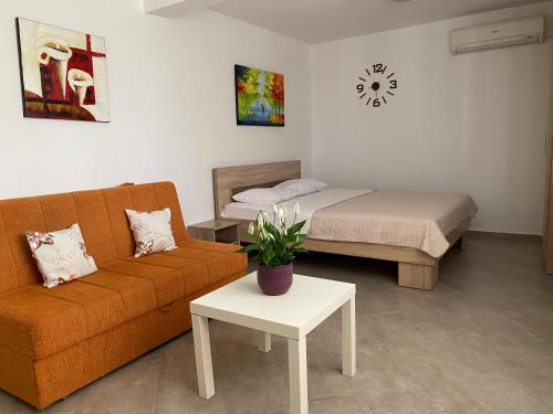 a living room with a couch and a bed at Dajkovic Apartmani in Bar
