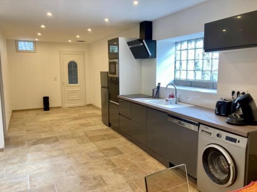 een keuken met een wasmachine, een wastafel en een wasmachine bij mas feuillade logement partagé in Nîmes