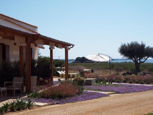 a garden with purple flowers next to a house at Borgo della Luna in Birgi Vecchi