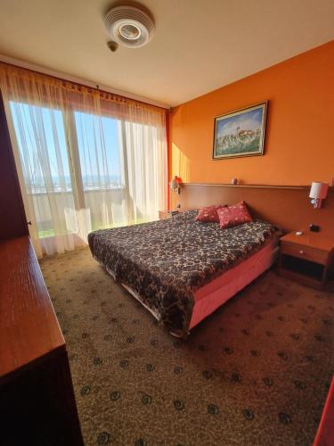 a hotel room with a bed and a large window at Bilberry Apartman in Balatonfüred
