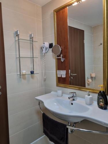 a bathroom with a sink and a mirror at Bilberry Apartman in Balatonfüred