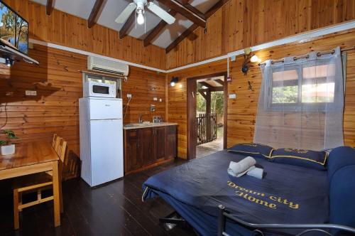 a kitchen with a bed in a room with wooden walls at פינה במעיין in Mishmār Hāyardin
