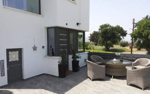 a patio with a table and chairs and a building at The Summer Haven in Polis Chrysochous