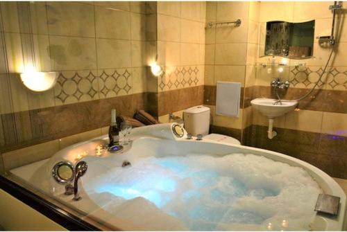 een badkamer met een bad, een toilet en een wastafel bij Хотел Дунав Свищов in Svishtov