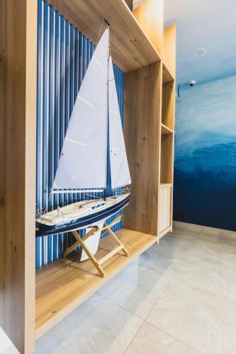 a small sail boat in a book shelf at Navigator in Palić