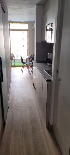a kitchen with a counter and a dining room with a table at A ESTRENAR PRECIOSOS APARTAMENTOS APARTHOTEL INTER2, NEW APARTMENTS lN APARTHOTEL 12 months open! self check in! RESERVA Garaje! in Salou