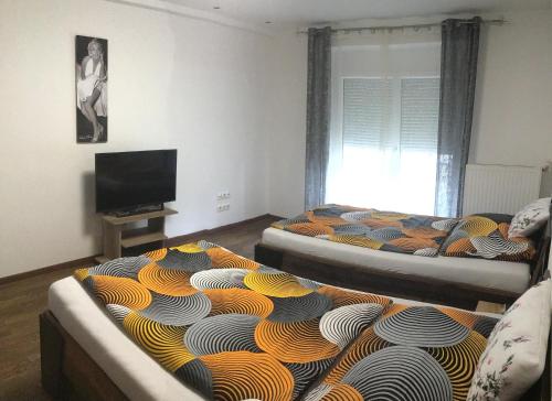 a living room with two beds and a flat screen tv at Nina Apartment in Wiener Neustadt