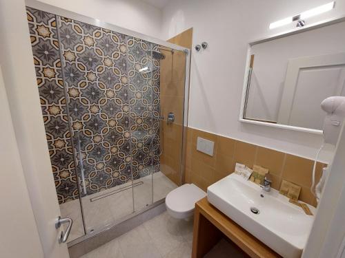 a bathroom with a shower and a toilet and a sink at Mistral Luxury Suites in Sorrento