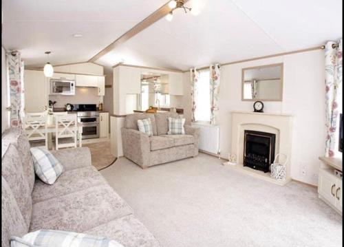 a living room with a couch and a fireplace at Seton Sands Haven Holiday Park - Platinum Caravan in Prestonpans