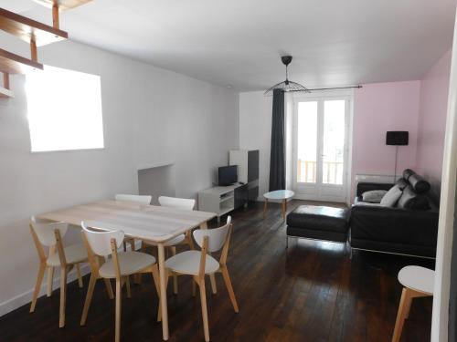 ein Wohnzimmer mit Tisch und Stühlen und einer Couch in der Unterkunft Chez le Paul in Viéville