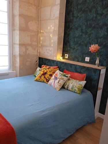 un lit avec des oreillers dessus dans une chambre dans l'établissement Appartement central typiquement bordelais, à Bordeaux