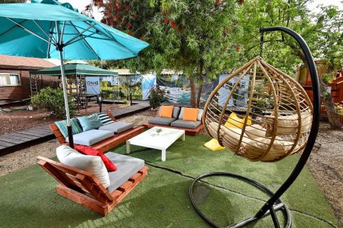 a patio with a swing and a hammock at פינה במעיין in Mishmār Hāyardin