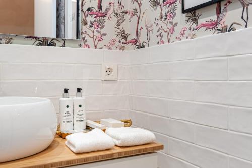a bathroom with a sink and towels on a counter at Art Suites by Casa de Indias in El Puerto de Santa María