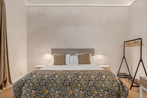a bedroom with a large bed and two tables at Art Suites by Casa de Indias in El Puerto de Santa María