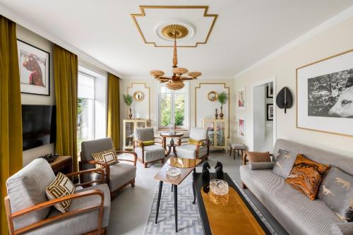 a living room filled with furniture and a chandelier at Suite with private bathroom at three bedroom interwar Villa Grabyte with daily spaces to share by pine forest on the bank of the river- 8min by car from old town in Kaunas