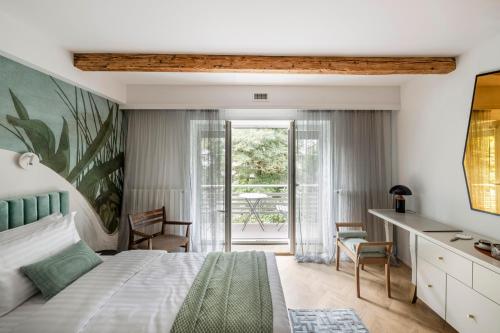 1 dormitorio con 1 cama y escritorio con sillas en Suite with private bathroom at three bedroom interwar Villa Grabyte with daily spaces to share by pine forest on the bank of the river- 8min by car from old town, en Kaunas