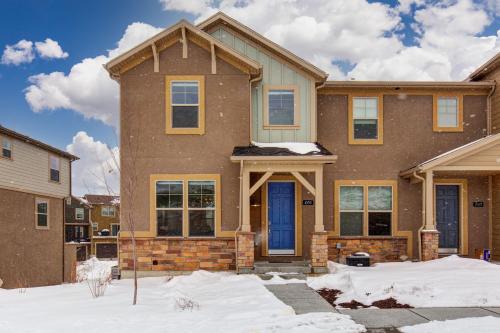 a house with a blue door in the snow at Wasatch Springs Getaway in Kamas