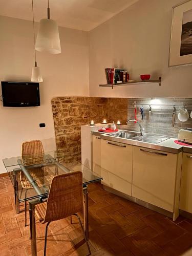 a kitchen with a sink and a table with chairs at MARMORE HOUSE in Collestatte