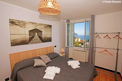 sypialnia z łóżkiem i dużym oknem w obiekcie Cav Gli Ulivi di Bogliasco parcheggio privato gratuito w mieście Bogliasco