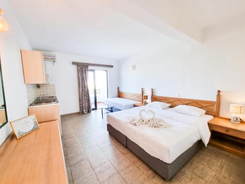 a bedroom with a large bed with white sheets at Penélope Hotel in Ialyssos
